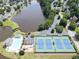 Aerial view of tennis courts, pool and pond, surrounded by lush greenery and neighborhood homes at 4000 Longlake Dr, Duluth, GA 30097