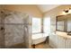 Well-lit bathroom features soaking tub, tiled shower, and white vanity at 4000 Longlake Dr, Duluth, GA 30097
