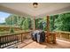 Covered back porch offers a relaxing space with a grilling area and serene backyard views at 4960 Norman Ct, Cumming, GA 30040