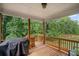 Covered back porch provides an outdoor space with a grilling station and views of lush greenery at 4960 Norman Ct, Cumming, GA 30040