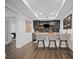 Chic basement bar area featuring counter seating, dark cabinetry, and stylish herringbone backsplash at 4960 Norman Ct, Cumming, GA 30040