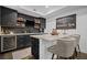 Modern basement bar features sleek black cabinetry, a wine fridge, and an elegant granite countertop at 4960 Norman Ct, Cumming, GA 30040