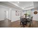 Well-lit dining room boasts hardwood floors, modern lighting, and rustic wood dining table set for six at 4960 Norman Ct, Cumming, GA 30040