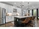 Modern kitchen with white cabinets, stainless steel appliances, and a large central island with barstool seating at 4960 Norman Ct, Cumming, GA 30040