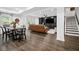 Open-concept living area with hardwood floors, a cozy leather sectional, and staircase to the upper level at 4960 Norman Ct, Cumming, GA 30040