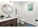 Modern bathroom featuring a round mirror, vanity, and tile floor at 8544 Plumtree Dr, Riverdale, GA 30274