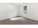 A cozy bedroom featuring neutral carpet and a sunlit window at 8544 Plumtree Dr, Riverdale, GA 30274