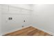 A functional laundry room featuring wood-look flooring and washer/dryer hookups at 8544 Plumtree Dr, Riverdale, GA 30274
