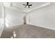 Bright main bedroom with tray ceiling, fan, and carpet flooring at 8544 Plumtree Dr, Riverdale, GA 30274