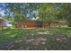 Spacious backyard with mature trees offering ample shade, partially fenced with a brick foundation at 2261 Star Mist Sw Dr, Atlanta, GA 30311