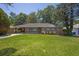 Charming brick ranch-style home featuring a well-maintained lawn and complemented by lush, mature trees at 2261 Star Mist Sw Dr, Atlanta, GA 30311
