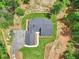 Aerial view of a home with a dark roof, driveway, and manicured lawn in a wooded setting at 2725 Glendale Ne Dr, Conyers, GA 30013