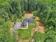 An aerial view shows a home with gray roof, stone front, sidewalk, driveway, landscaping, and a well-manicured lawn at 2725 Glendale Ne Dr, Conyers, GA 30013