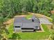 An aerial view of the home showcasing its backyard and landscaping, bordered by a dense tree line at 2725 Glendale Ne Dr, Conyers, GA 30013