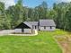 New exterior features white painted brick, vertical siding, black trim, new roof, landscaping, and wooded backdrop at 2725 Glendale Ne Dr, Conyers, GA 30013