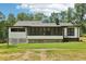 A single-story home with a dark roof, a screened porch, white siding, and dark trim set on a large lot at 2725 Glendale Ne Dr, Conyers, GA 30013