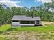 A single-story home with a dark roof, a screened porch, white siding, and dark trim set on a large lot at 2725 Glendale Ne Dr, Conyers, GA 30013