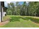 A spacious backyard with a gentle slope, offering ample green space and a peaceful wooded backdrop at 2725 Glendale Ne Dr, Conyers, GA 30013