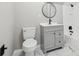 Modern bathroom features a sleek vanity, round mirror, and a toilet with marble tile flooring at 2725 Glendale Ne Dr, Conyers, GA 30013