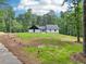 Beautiful exterior features a white painted brick, vertical siding, black trim, new roof, and manicured lawn at 2725 Glendale Ne Dr, Conyers, GA 30013