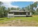 Side exterior view of home with large screened windows and green lawn surrounded by mature trees at 2725 Glendale Ne Dr, Conyers, GA 30013