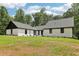 Beautiful exterior features a white painted brick, vertical siding, black trim, new roof, and manicured lawn at 2725 Glendale Ne Dr, Conyers, GA 30013