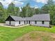 Beautiful exterior features a white painted brick, vertical siding, black trim, new roof, and manicured lawn at 2725 Glendale Ne Dr, Conyers, GA 30013