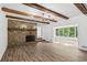 Bright living room featuring a stone fireplace, wood beams, and hardwood floors at 2725 Glendale Ne Dr, Conyers, GA 30013