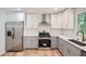 Bright kitchen features stainless steel appliances and two-tone cabinets against wood flooring at 290 Bromack Se Dr, Atlanta, GA 30315