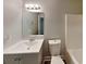 This bathroom offers a large mirror with vanity lighting, a gray vanity, and a white toilet at 1232 Pinedale Nw Cir, Conyers, GA 30012