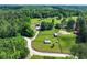 Aerial shot of the property featuring the house, pastures, outbuildings, and wooded areas at 1780 Penn Camp Road, Douglasville, GA 30134