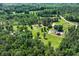 Aerial view of the property showcasing the house, outbuildings, and surrounding wooded land at 1780 Penn Camp Road, Douglasville, GA 30134