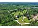 Sprawling acreage with a house, barn, and outbuildings surrounded by lush greenery and mature trees at 1780 Penn Camp Road, Douglasville, GA 30134