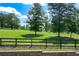Scenic backyard view with lush greenery, mature trees, and a charming fence line, creating a serene outdoor space at 1780 Penn Camp Road, Douglasville, GA 30134