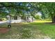 Serene backyard featuring a lush lawn, mature trees, and a home with a charming exterior at 1780 Penn Camp Road, Douglasville, GA 30134
