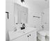 Bright bathroom featuring a white vanity with black hardware, a large mirror, and a shower-tub combo at 1780 Penn Camp Road, Douglasville, GA 30134