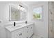 Modern bathroom featuring a double vanity, sleek black fixtures, and a window with natural light at 1780 Penn Camp Road, Douglasville, GA 30134