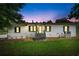 Exterior of a white home with black shutters at dusk, creating a warm and inviting atmosphere at 1780 Penn Camp Road, Douglasville, GA 30134