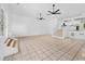 Spacious living room with neutral tile floors, ceiling fans, and a staircase leading to the upper level at 1780 Penn Camp Road, Douglasville, GA 30134