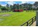 Exterior view of a pasture with fencing, outbuildings, and lush green grass for livestock at 1780 Penn Camp Road, Douglasville, GA 30134