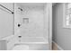 Updated bathroom with marble-style tile, a shower and tub combination, and modern fixtures, creating a clean and functional space at 2984 E Paulding Dr, Dallas, GA 30157