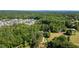 Expansive aerial view of homes surrounded by lush greenery, and distant mountains at 7376 Bates Dr, Cumming, GA 30040