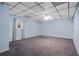 Unfinished basement space with paneled ceiling and blue walls at 7376 Bates Dr, Cumming, GA 30040