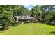 Beautiful brick home on a lush green lawn surrounded by mature trees at 7376 Bates Dr, Cumming, GA 30040