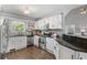 Bright kitchen with white cabinets, dark countertops and stainless steel appliances at 7376 Bates Dr, Cumming, GA 30040
