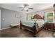 A main bedroom with a ceiling fan, hardwood floors and a decorative headboard at 7376 Bates Dr, Cumming, GA 30040