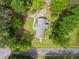 Overhead view of the home's roof, backyard, deck and the driveway, surrounded by mature trees at 8415 Ridge Rd, Fairburn, GA 30213