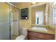 Bright bathroom featuring shower stall, mirrored vanity, wood cabinets, and tiled floors at 8415 Ridge Rd, Fairburn, GA 30213