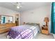 Cozy bedroom with hardwood floors, ceiling fan, dresser, night stand, and ample natural light at 8415 Ridge Rd, Fairburn, GA 30213