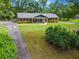 Well-maintained ranch-style house with lush greenery, a long driveway and manicured landscaping at 8415 Ridge Rd, Fairburn, GA 30213